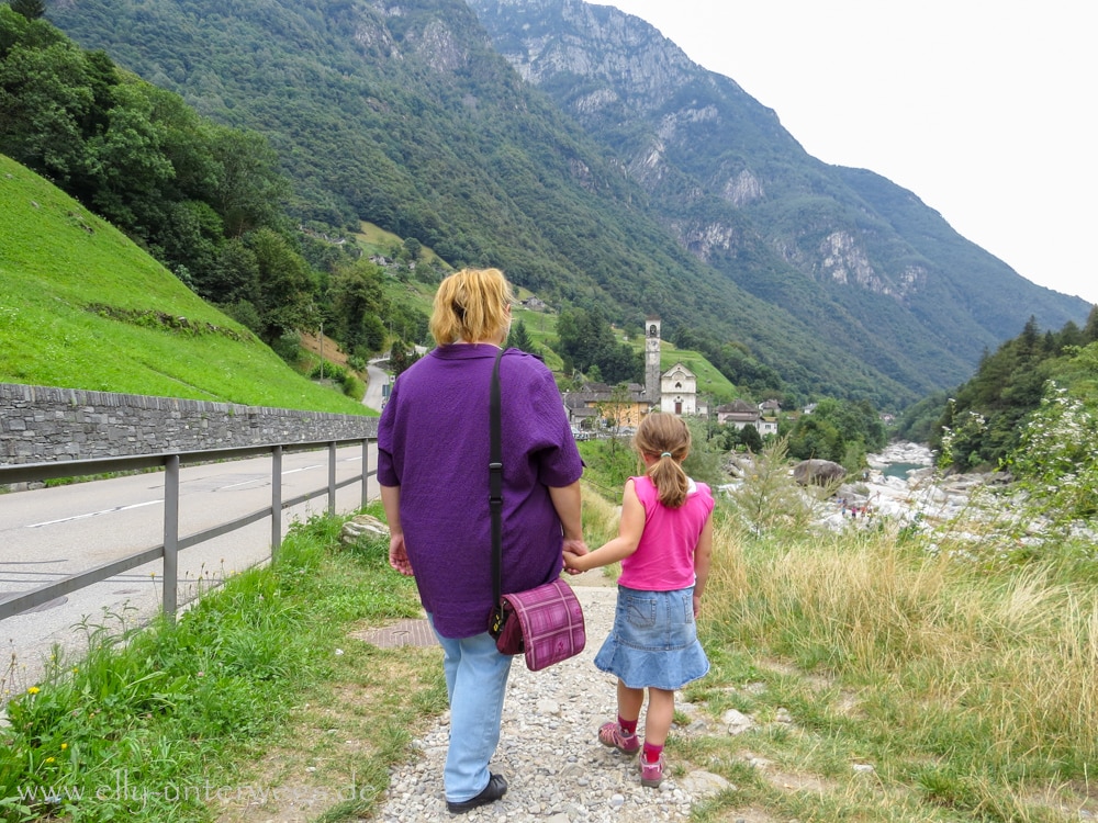 Person auf einem Weg im Verzascatal mit Bergen im Hintergrund