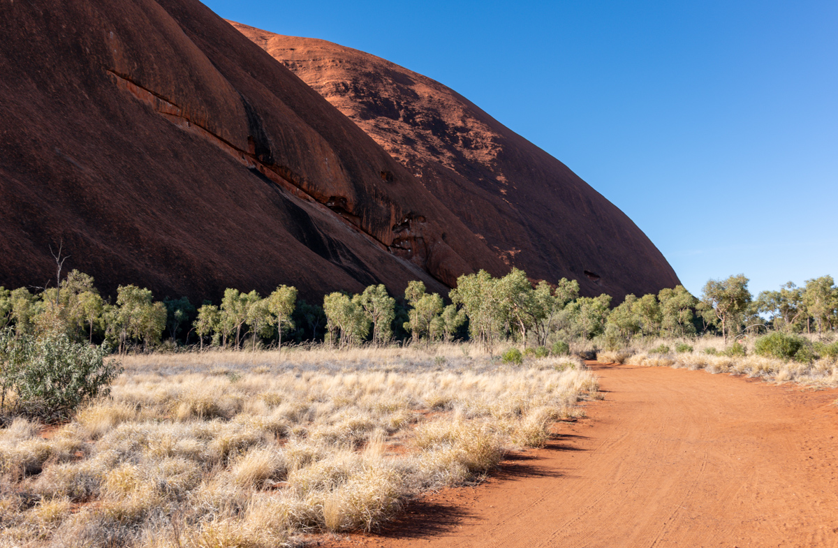 Roter Monolith mit Vegetationssaum am Fuß