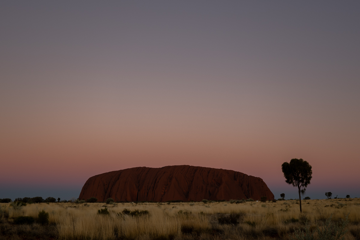 Untergehende Sonne am Horizont nahe Uluru